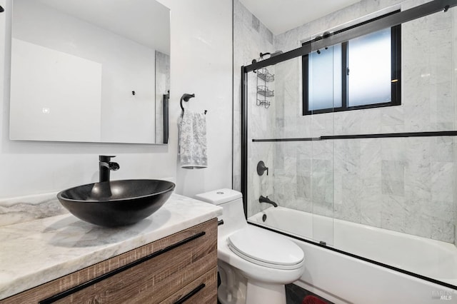 full bathroom with vanity, toilet, and combined bath / shower with glass door