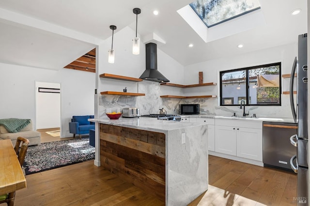 kitchen with pendant lighting, wall chimney range hood, dishwasher, light stone countertops, and white cabinets