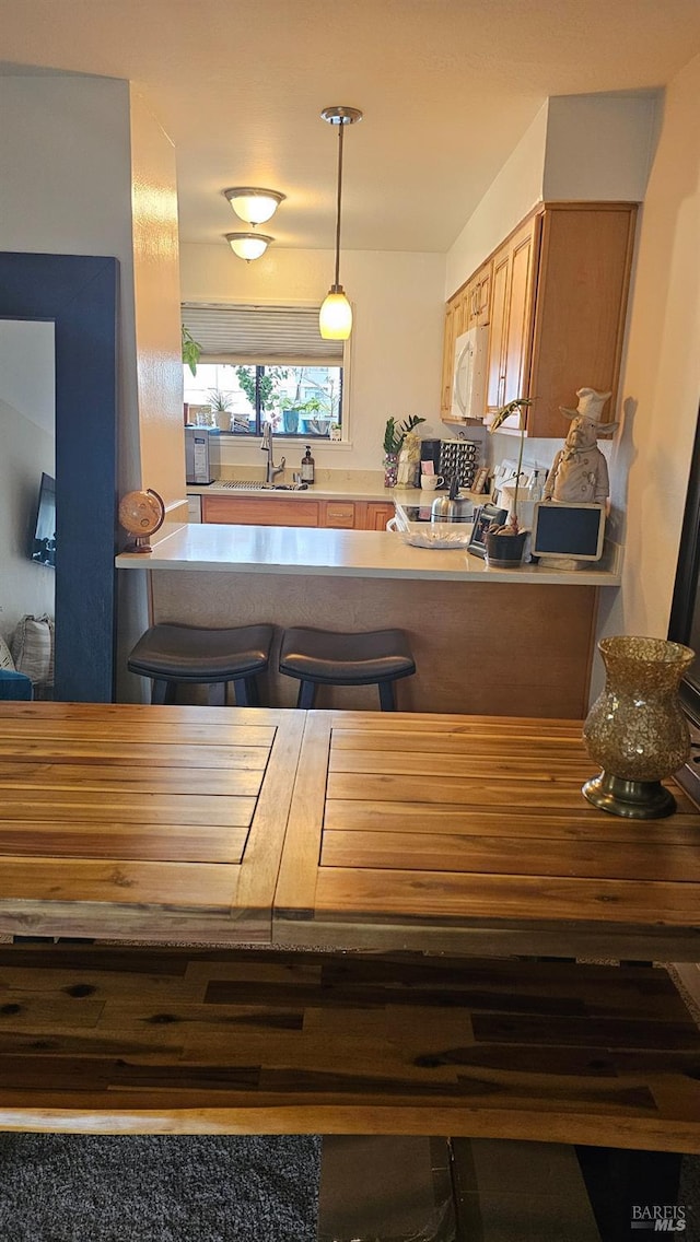 kitchen featuring range, sink, and hanging light fixtures