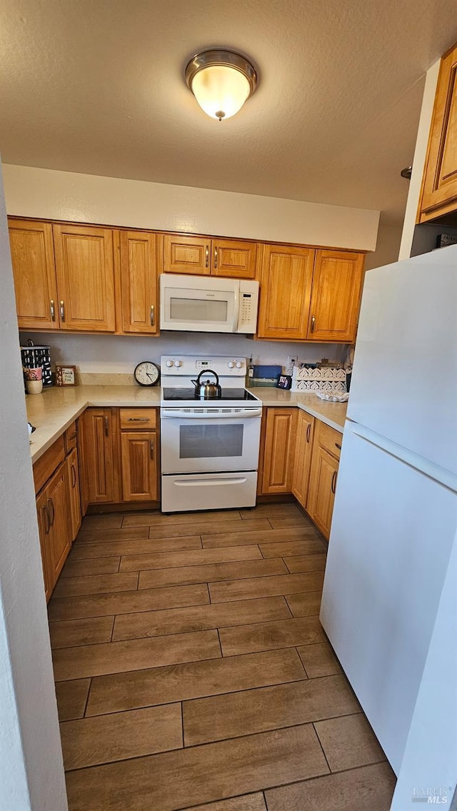 kitchen with a textured ceiling and white appliances