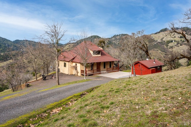 view of front of home with a mountain view, a front yard, and covered porch