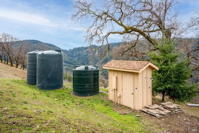 view of outdoor structure with a yard and a mountain view