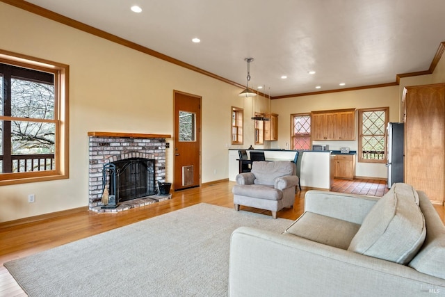 living room with light wood-type flooring, ornamental molding, and a brick fireplace