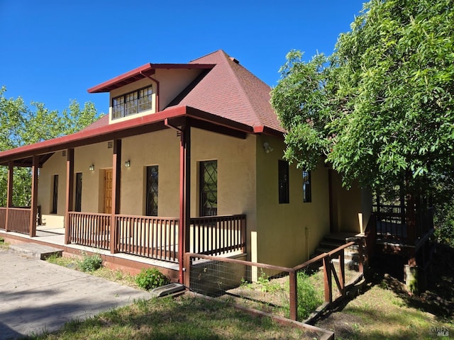 14950 Ridgeview Rd, Willits, CA 95490 - view of property exterior featuring stucco siding, covered porch, and a shingled roof