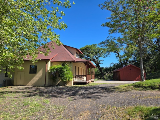 14950 Ridgeview Rd, Willits, CA 95490 - view of home's exterior featuring a garage, central air condition unit, driveway, an outdoor structure, and stucco siding