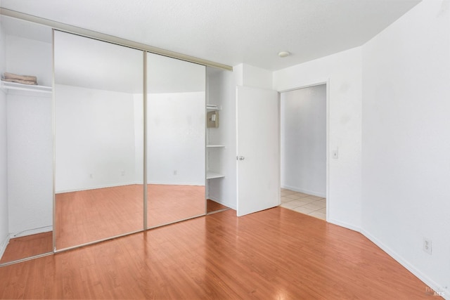 unfurnished bedroom with a closet and light wood finished floors