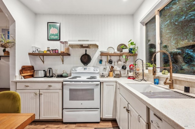 kitchen with white appliances, light hardwood / wood-style floors, sink, and white cabinets