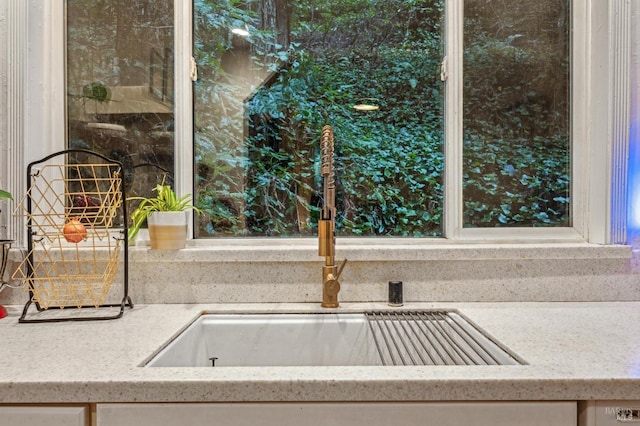 room details featuring sink and light stone countertops