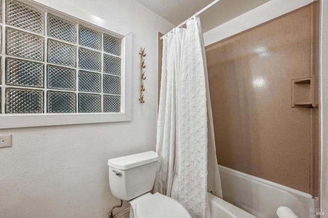 bathroom with shower / bath combination with curtain and toilet