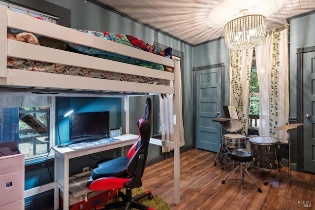 bedroom featuring multiple windows, a notable chandelier, and hardwood / wood-style flooring