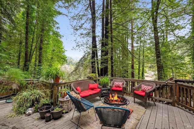 deck with an outdoor living space with a fire pit