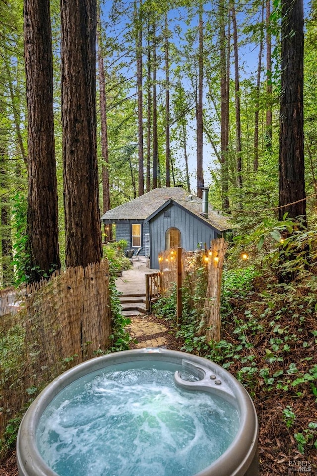 view of swimming pool featuring a wooden deck and an outdoor hot tub