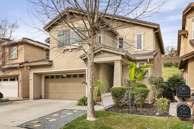 view of front of property with a garage, driveway, a tiled roof, and stucco siding