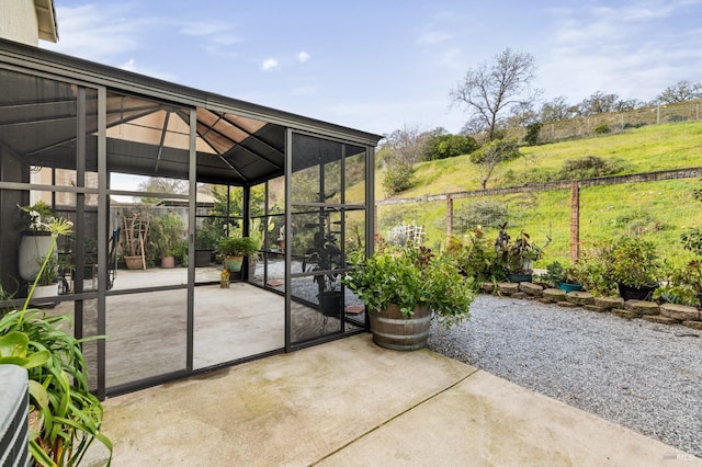 view of patio featuring a gazebo, fence, and a lanai