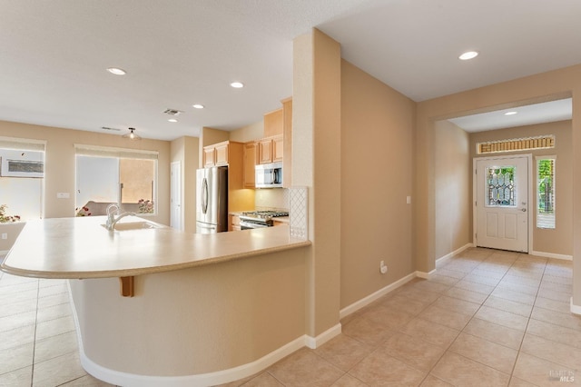 kitchen with a sink, light countertops, stainless steel appliances, recessed lighting, and light tile patterned floors