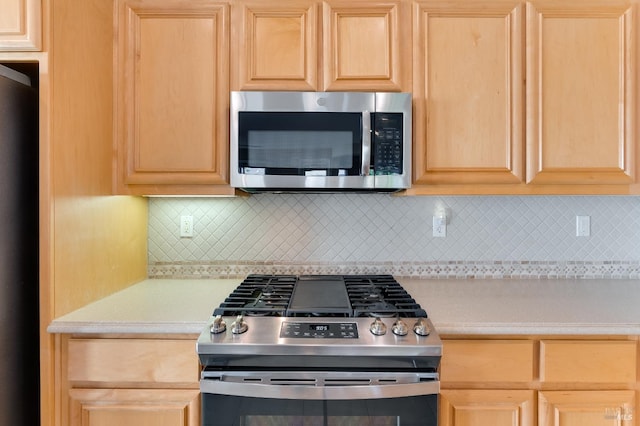 kitchen featuring light countertops, decorative backsplash, light brown cabinetry, and stainless steel appliances