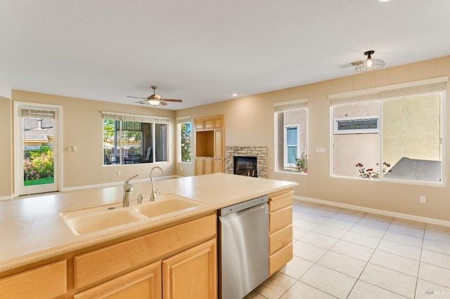 kitchen with light brown cabinetry, dishwasher, a sink, light tile patterned floors, and light countertops