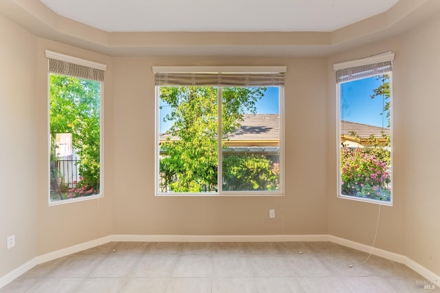 unfurnished room featuring baseboards, light tile patterned floors, and a healthy amount of sunlight