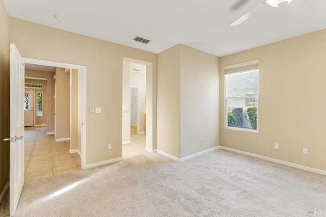 unfurnished bedroom featuring visible vents, a ceiling fan, baseboards, and light colored carpet