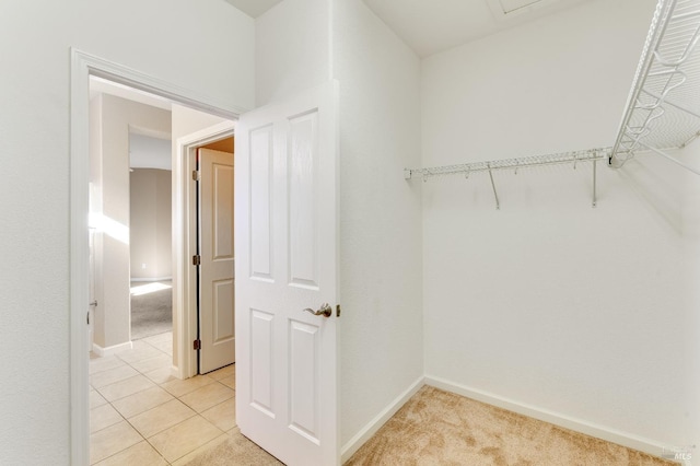 spacious closet with light tile patterned floors and light colored carpet