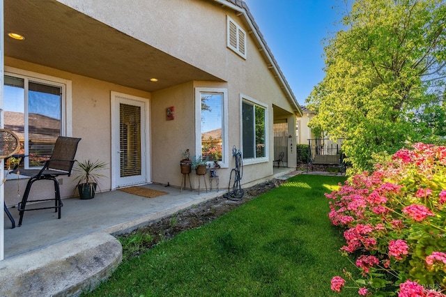 exterior space featuring a yard, a patio area, and stucco siding