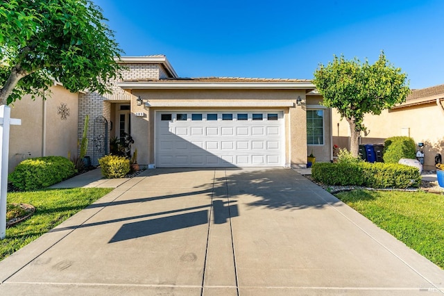 view of front facade featuring an attached garage, stucco siding, and driveway