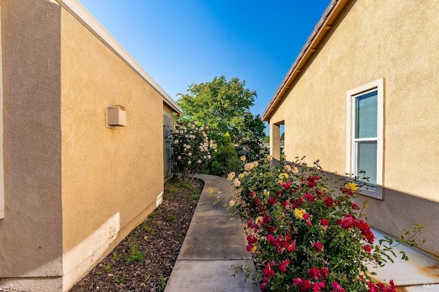view of side of property featuring stucco siding and fence