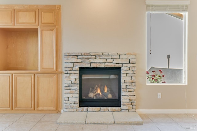 room details featuring baseboards and a stone fireplace