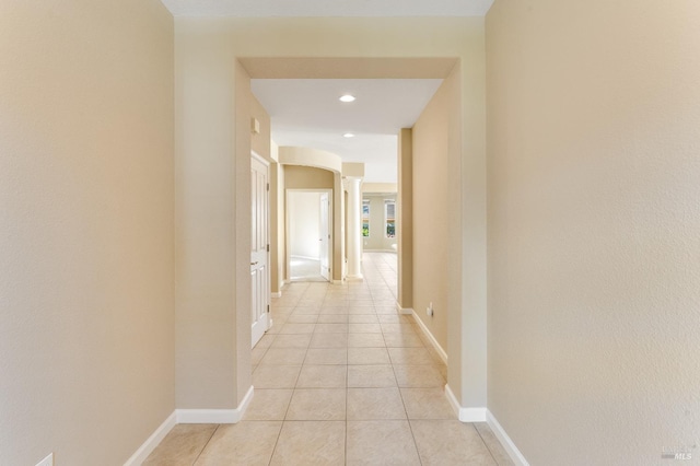 corridor featuring ornate columns, baseboards, recessed lighting, and light tile patterned floors