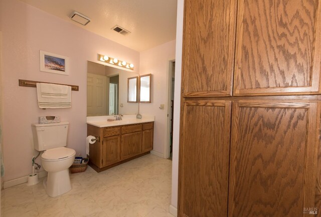 bathroom featuring toilet, vanity, baseboards, and visible vents