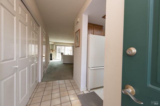 corridor with light tile patterned floors and light carpet