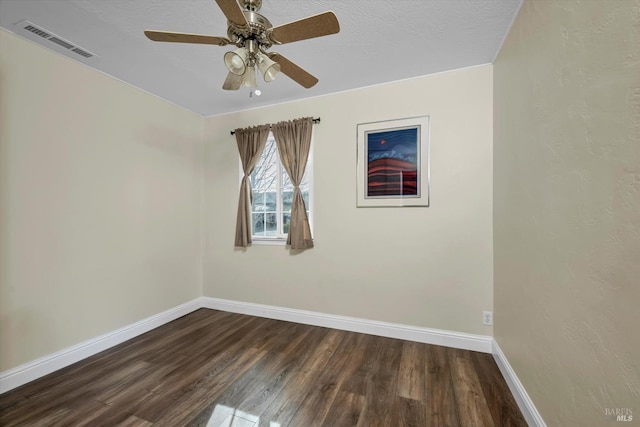 unfurnished room with a textured ceiling, dark wood-type flooring, and ceiling fan