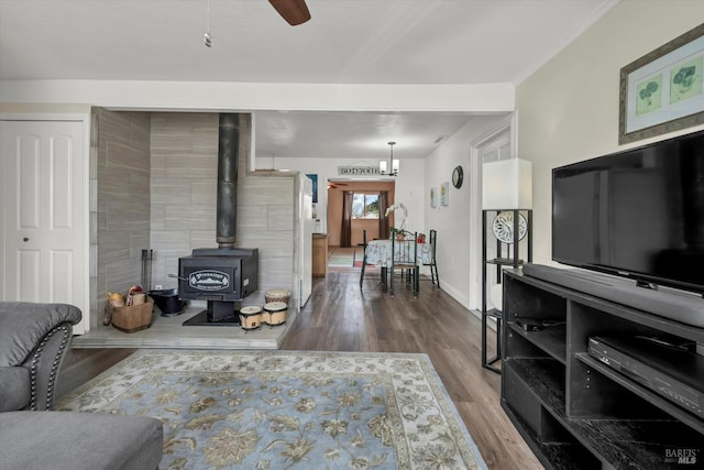 living room with a wood stove, hardwood / wood-style floors, and ceiling fan