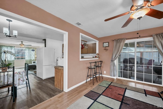 interior space with dark hardwood / wood-style flooring and ceiling fan with notable chandelier