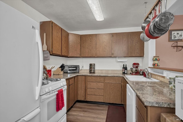 kitchen with sink, white appliances, and dark hardwood / wood-style floors