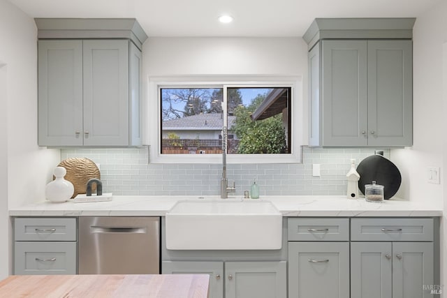 kitchen featuring dishwasher, sink, gray cabinetry, and decorative backsplash