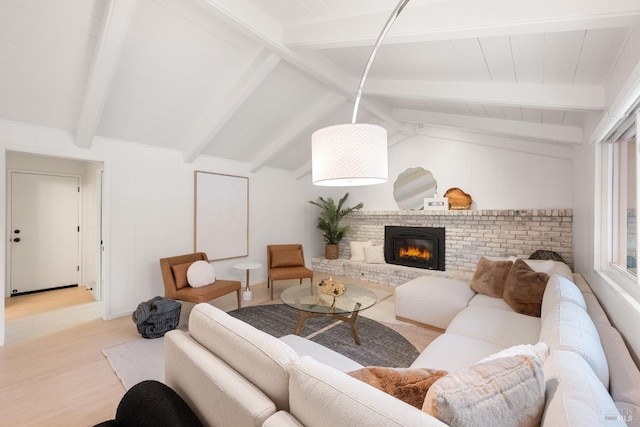 living room with a fireplace, lofted ceiling with beams, and light hardwood / wood-style floors