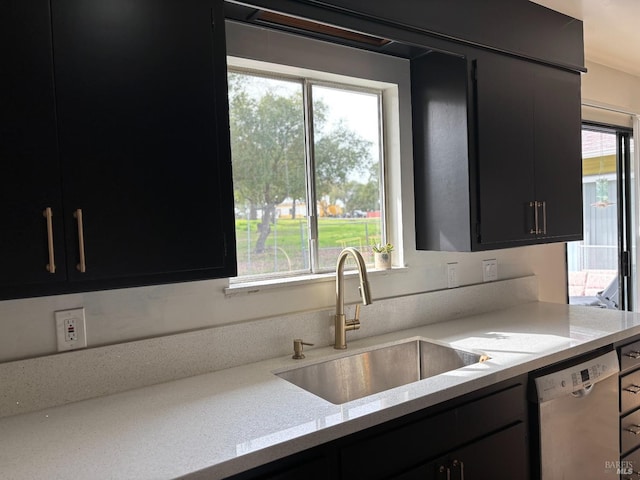 kitchen with sink, dishwasher, light stone countertops, and a wealth of natural light