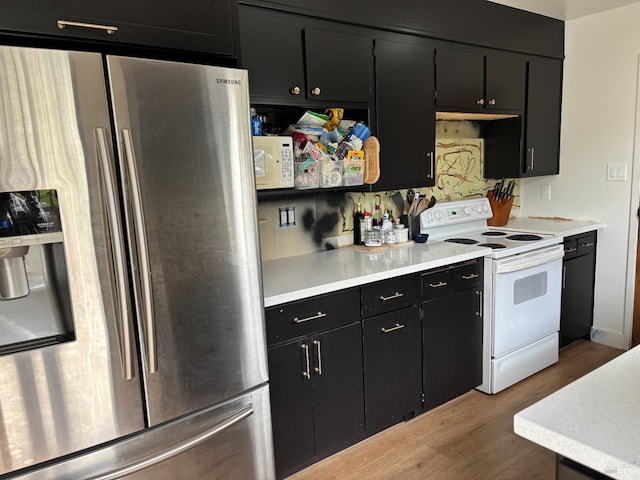 kitchen featuring white electric range, stainless steel refrigerator with ice dispenser, and light wood-type flooring