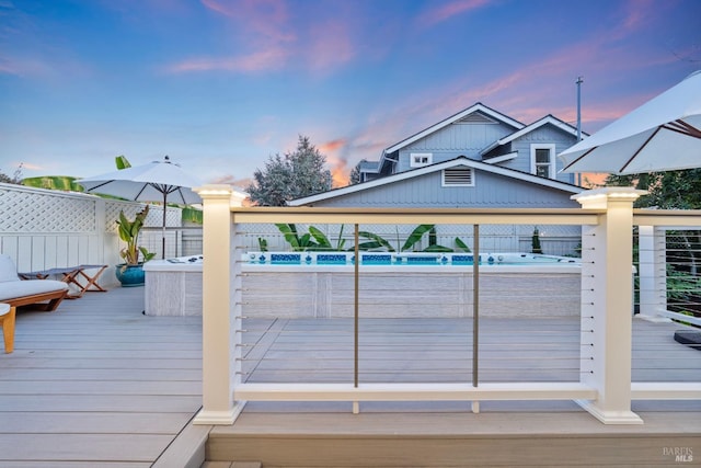 pool at dusk with a wooden deck