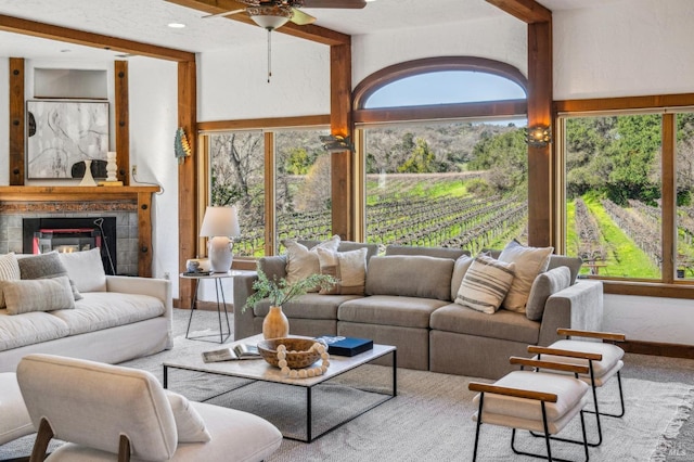 living room featuring a tiled fireplace, a wealth of natural light, and beamed ceiling