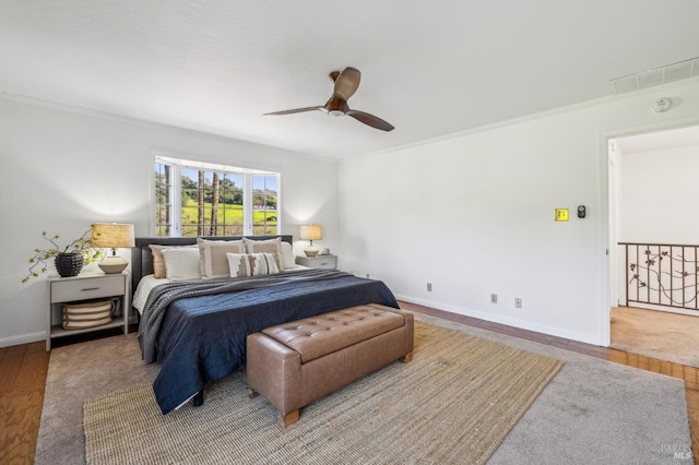 bedroom featuring crown molding, wood-type flooring, and ceiling fan