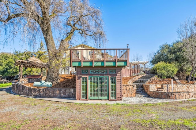 rear view of house featuring a hot tub and a lawn