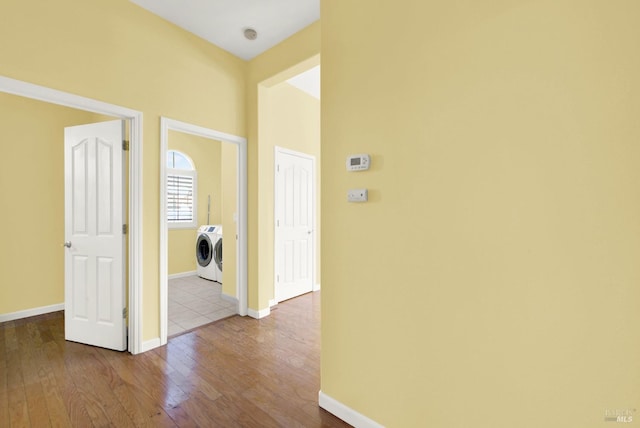 hallway featuring hardwood / wood-style flooring and separate washer and dryer