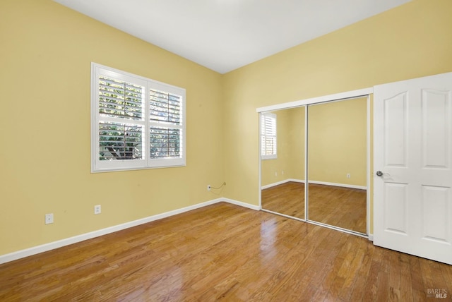 unfurnished bedroom featuring hardwood / wood-style flooring and a closet