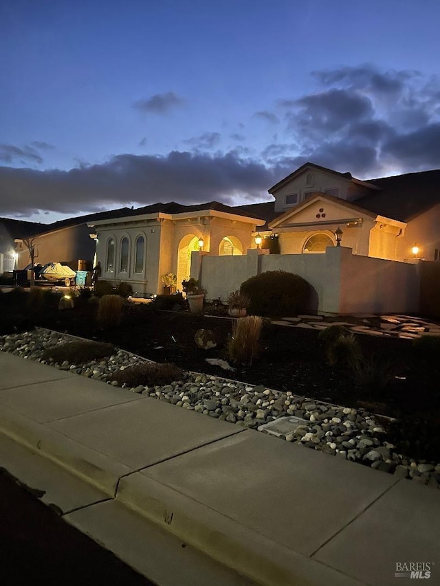 mediterranean / spanish house with a fenced front yard