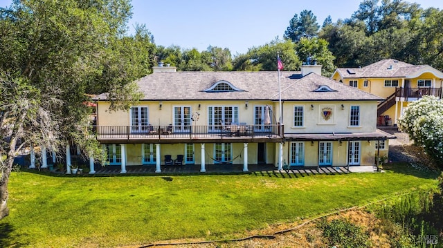 back of house with a lawn, french doors, and a deck