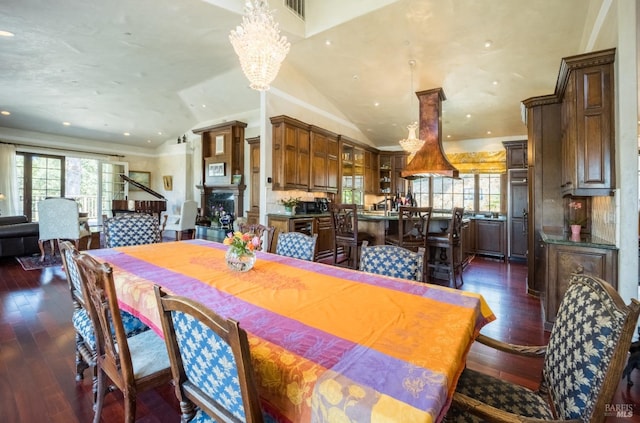 dining space with vaulted ceiling, dark wood-type flooring, and a notable chandelier