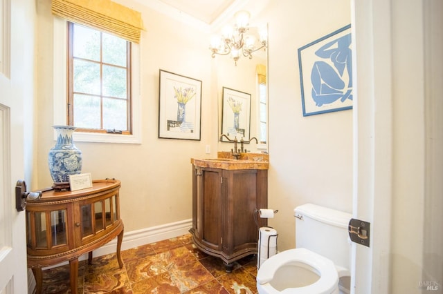 bathroom with vanity, toilet, and an inviting chandelier