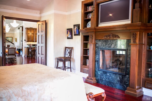 bedroom featuring crown molding, dark wood-type flooring, and a fireplace